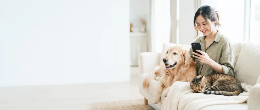 Woman with a dog and cat on a sofa